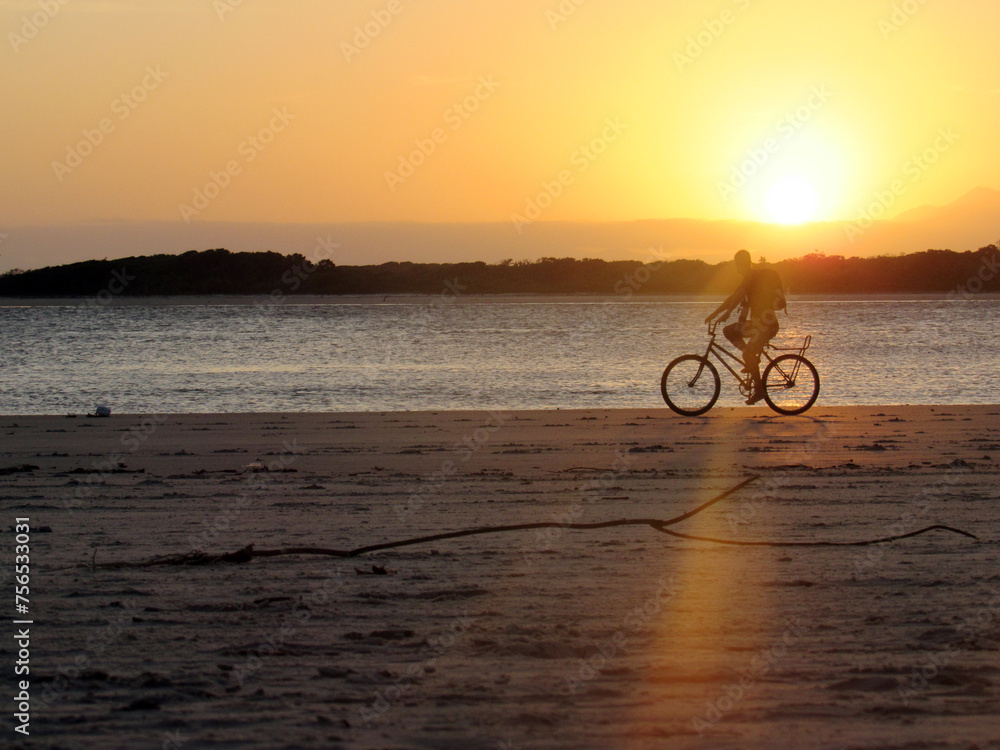 Fototapeta premium silhouette of a cyclist on the beach