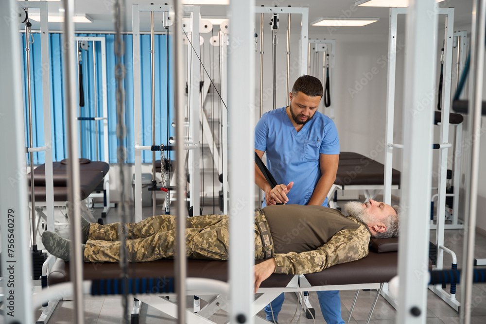 Military patient does exercises to stretch his arm muscles Military patient does exercises to stretch his arm muscles