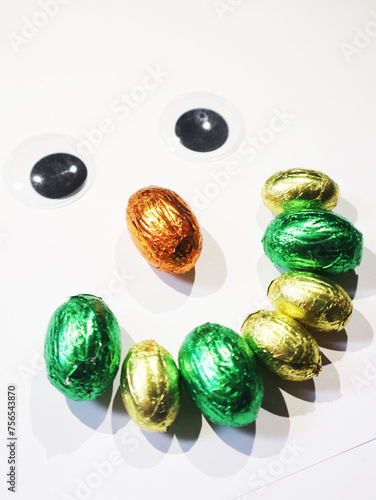 Eyes and smile with easter egg chocoloate in green and yellow colors.
The eyes and smile with easter egg made of chocoloate in green and yellow colors has a white background and space for custom conte photo