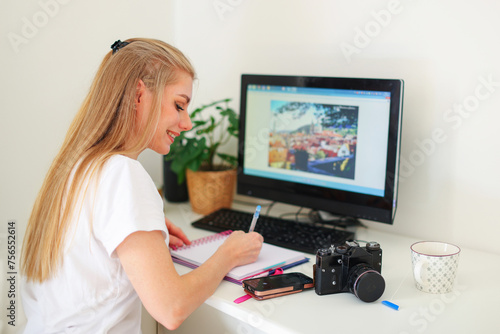 young woman studying online while sitting at the table at home
