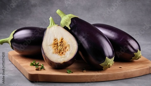 Cut into pieces of ripe eggplant on a wooden cutting board. On a gray background photo
