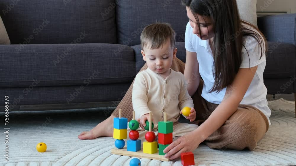 Little Caucasian son and happy mother having fun and playing with toys, spending leisure time at home. Wooden puzzle toy, childhood concept. Little Caucasian son and happy mother having fun and playing with toys, spending leisure time at home. Wooden puzzle toy, childhood concept.