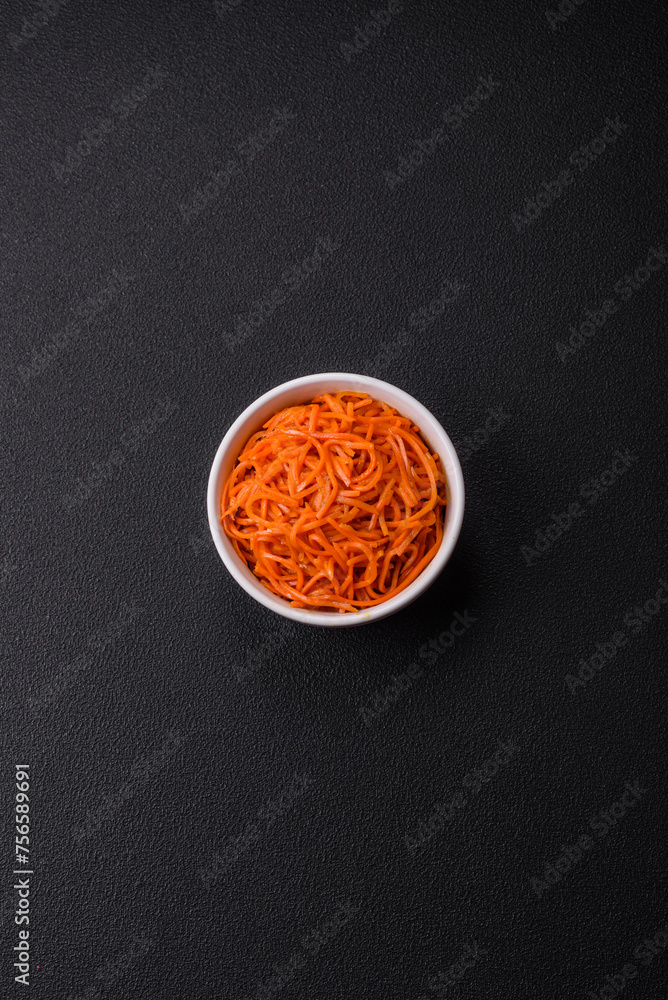 Tasty spicy Korean carrot with spices and herbs on a dark concrete background Tasty spicy Korean carrot with spices and herbs on a dark concrete background