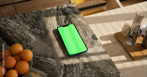Smartphone place on kitchen table, Green screen telephone, Close up display mobile phone with mock up, Chroma key monitor