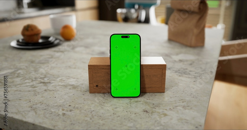 Smartphone place on kitchen table, Green screen telephone, Close up display mobile phone with mock up, Chroma key monitor
