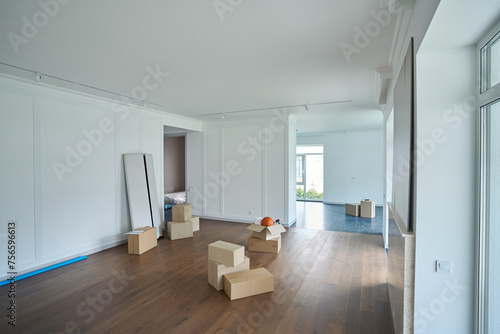 Modern comfortable sunny townhouse with cardboard boxes on floor during moving