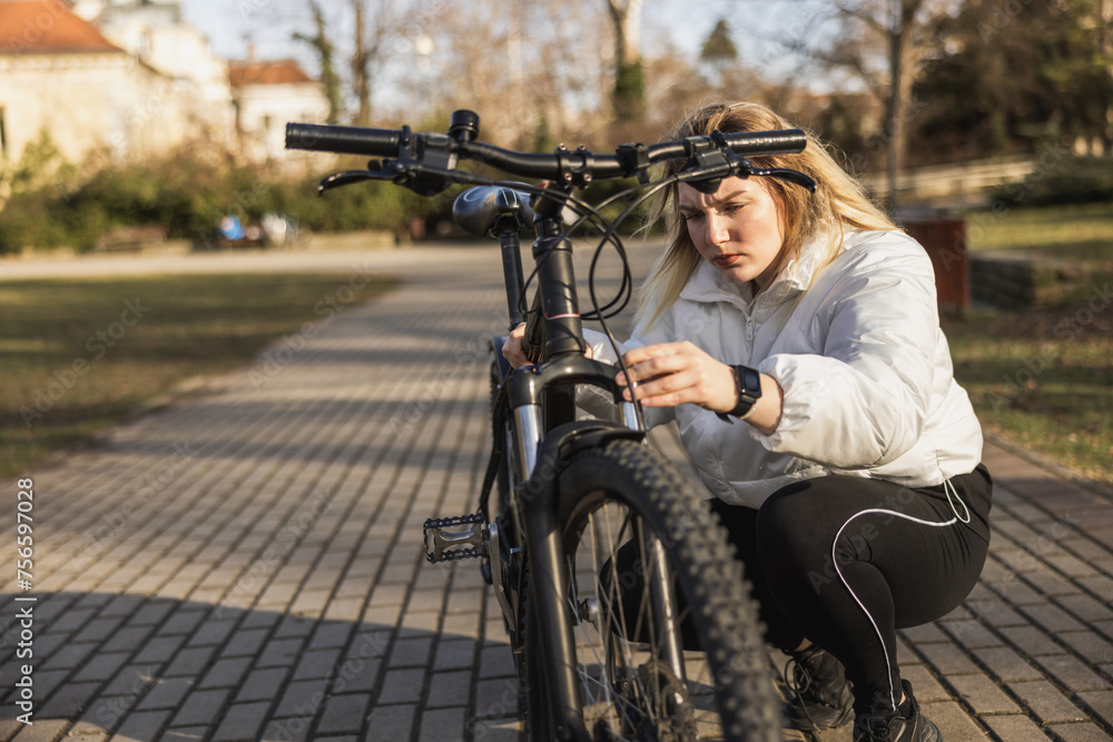 Woman Repairing Her Bicycle in a Sunny Park
