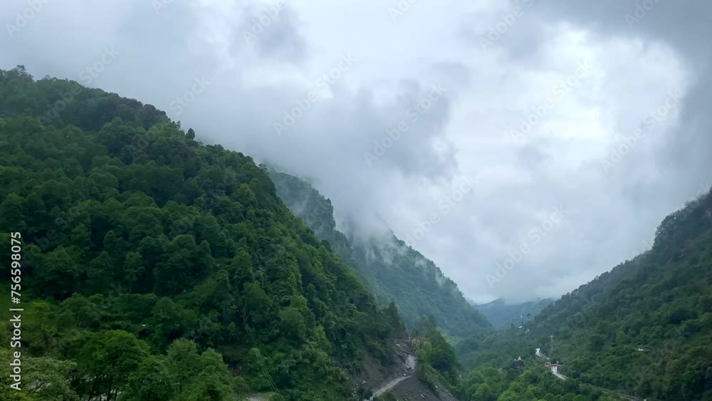 Storm clouds over mountains of Jang town deep in the jang valley in tawang district of arunachal pradesh and surrounded by high mountains on a bright morning rainy day in arunachal pradesh in India. Storm clouds over mountains of Jang town deep in the jang valley in tawang district of arunachal pradesh and surrounded by high mountains on a bright morning rainy day in arunachal pradesh in India.