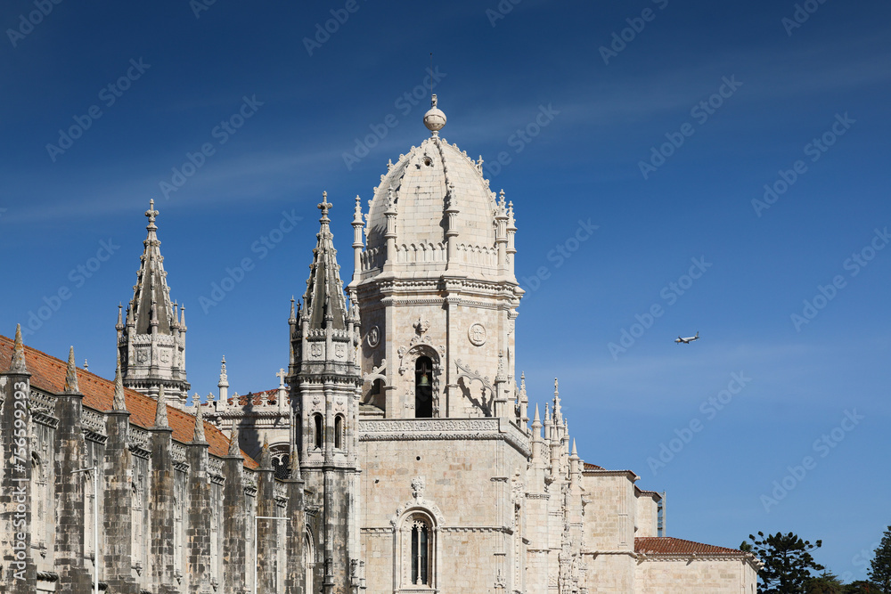 Jeronimos Monastery in Lisbon and Santa Maria de Belem Church landmark buildings in a photo during a sunny day with blue sky. Travel to Lisbon, Portugal.