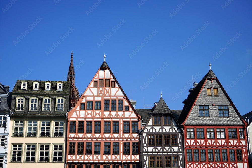 Restaurierte Fassaden von traditionellen Fachwerkhäusern vor blauem Himmel im Sonnenschein in der Altstadt am Römerberg in Frankfurt am Main in Hessen