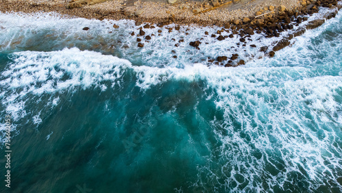 Dark-blue ocean wave crashing onto the rocky shore. Cantabria, Spain. photo