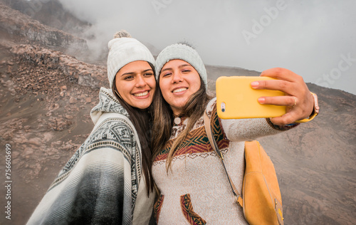 retrato de dos amigas felices tomando auto foto de vacaciones en la montaña con el celular  photo