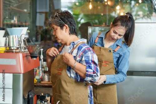 Wallpaper Mural Adorable Asian daughter businessman small business cafe owner tying suspenders retired mother was on  pension behind the coffee machine counter before opening the shop to welcome customers Torontodigital.ca