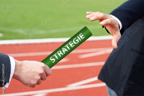 Businessmen pass baton with German word Strategie means Strategy in rely race in stadium photo