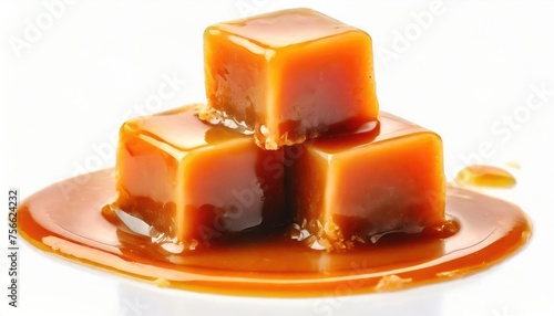 Three sweet caramel candy cubes topped with caramel sauce isolated on white background 