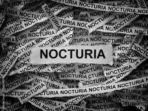 Strips of newspaper with the words Nocturia typed on them. Black and white. Close up. photo