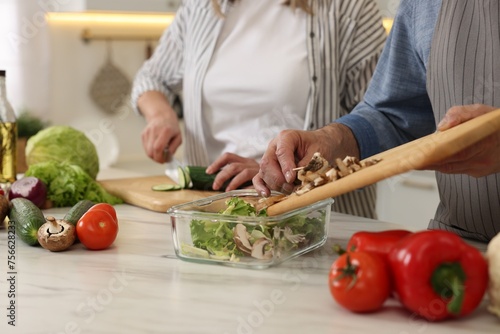 Senior couple cooking together in kitchen, closeup