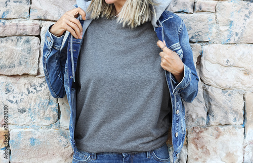 Gray tshirt mockup. Girl grey t shirt template. Woman wearing athletic heather gray t shirt for your design. Pepper ,stone wall, denim jacket