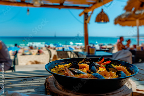 Spanish paella with seafood on a wooden table on the beach