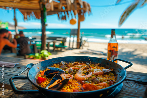 Spanish paella with seafood on a wooden table on the beach