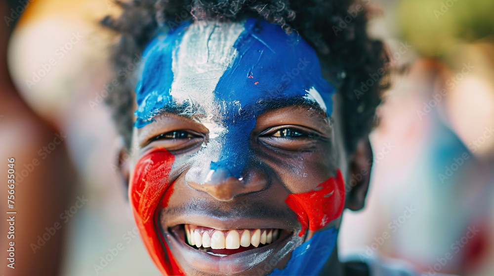 A joyful young dark-skinned guy with a face painted in the blue and red colors of the French flag welcomes the event