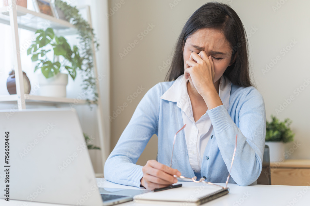 Exhausted, asian young business woman working at office desk, took off eye glasses, massage rubbing nose from dry eyes, suffer on work hard, using laptop computer at office home, problem overtime job. Exhausted, asian young business woman working at office desk, took off eye glasses, massage rubbing nose from dry eyes, suffer on work hard, using laptop computer at office home, problem overtime job.