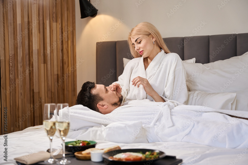 Couple in love is basking on a large bed