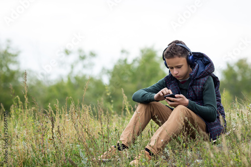 Teenager in headphones with a phone in his hands