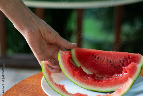 Portrait of young handsome man eating watermelon, man holding watermelon. Close up portrait of a man with slice of watermelon.