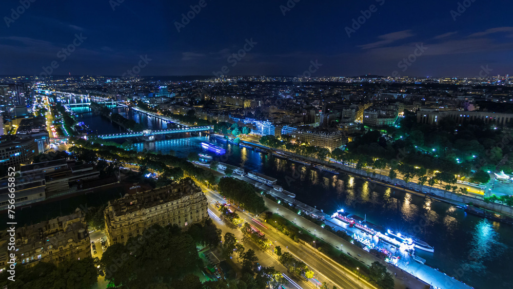 Aerial night timelapse view of Paris City and Seine river shot on the top of Eiffel Tower
