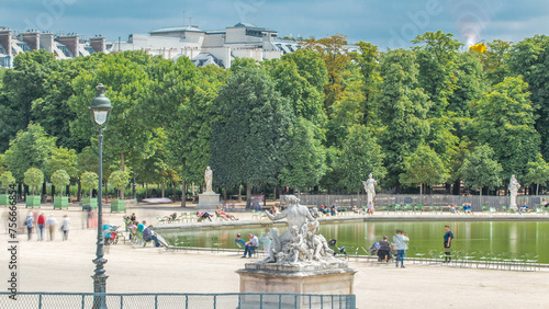 People relaxing in Tuileries Palace open air park near Louvre museum timelapse. Paris, France