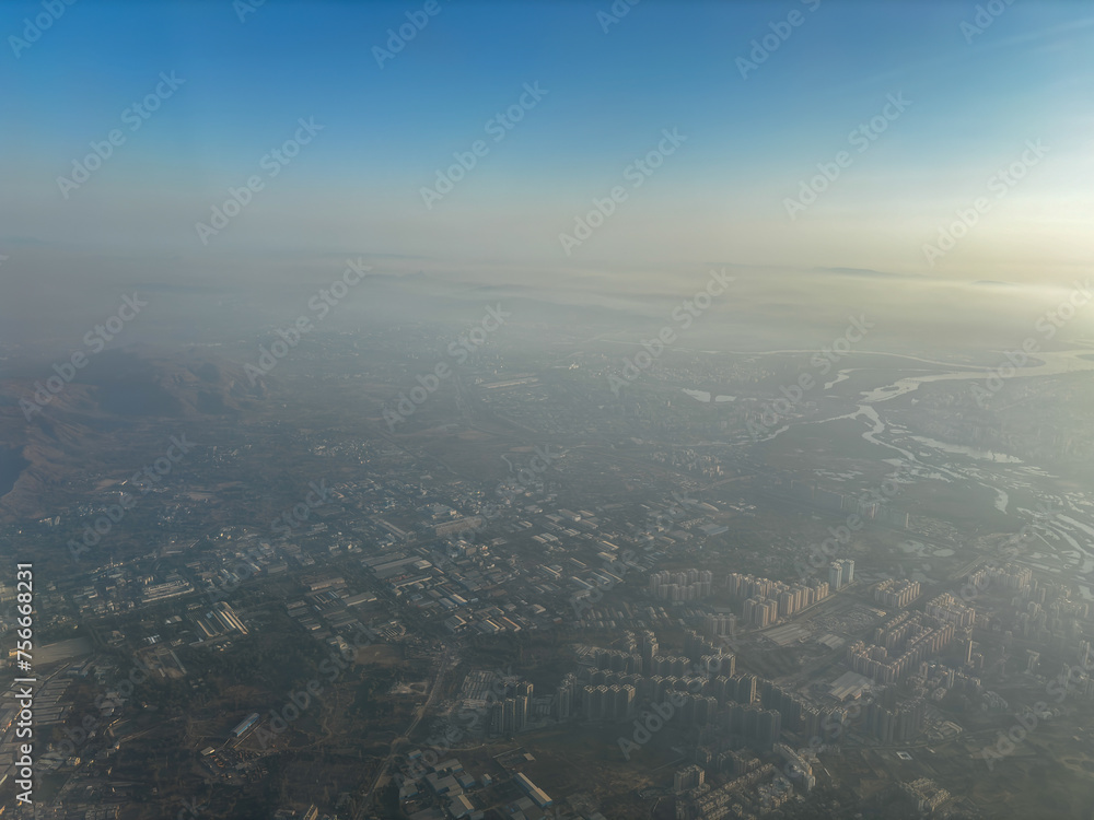 A city is seen from above with a hazy atmosphere