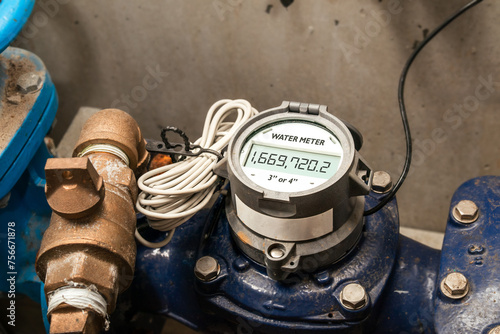 Water meter in building with commercial and residential units. Digital measuring device for water usage of property and accuracy in billing of water consumption. 3 or 4 inches. Selective focus.