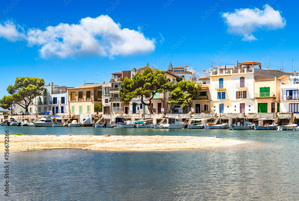 Fototapeta premium Line of houses with boats at the port of Portocolom with a sandbank in front - 8457