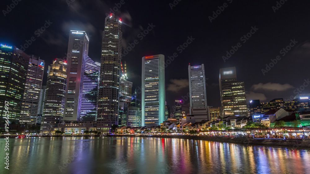 Singapore quay with tall skyscrapers in the central business district on Boat Quay night timelapse hyperlapse