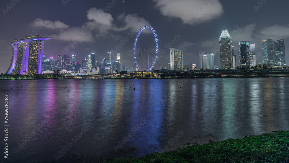 Obraz premium Downtown skyline of Singapore as viewed from across the water from The Garden East night timelapse. Singapore.