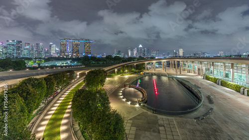 Aerial view Singapore city skyline with colorful fountain at Marina barrage garden night timelapse.