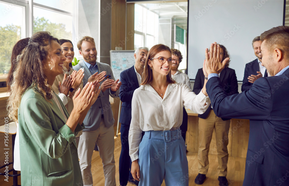 © Studio Romantic - Team of happy business people celebrating success together. Group of men and women having fun at work in office. Smiling female worker high fives colleague while others clap hands. Teamwork concept © Studio Romantic - Team of happy business people celebrating success together. Group of men and women having fun at work in office. Smiling female worker high fives colleague while others clap hands. Teamwork concept