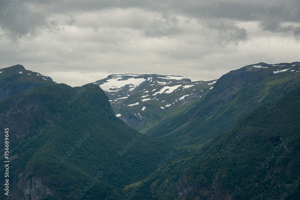 Nature view of Norwegian mountains from stegastein viewpoint on a cloudy summer day. Blue uv radiation on the mountains.