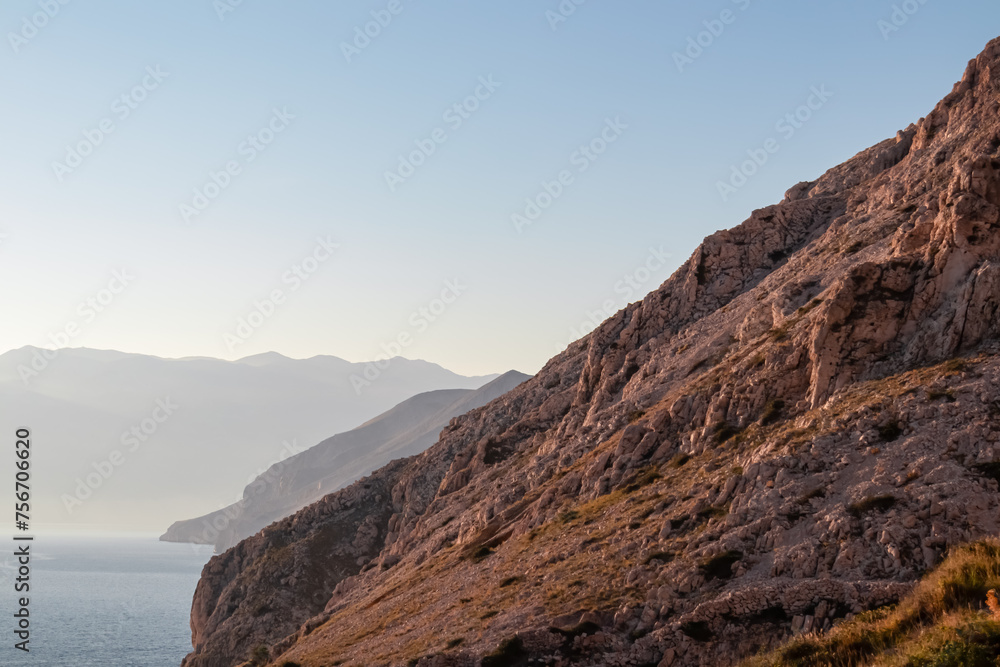 Coastal hiking trail along steep cliffs and mountains near tourist town Baska, Krk island, Primorje-Gorski Kotar, Croatia, Europe. Majestic coastline of Adriatic Mediterranean Sea in Kvarner Bay. Hike