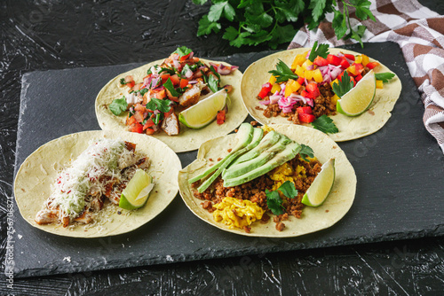 set of delicious fresh colorful tacos on a dark background