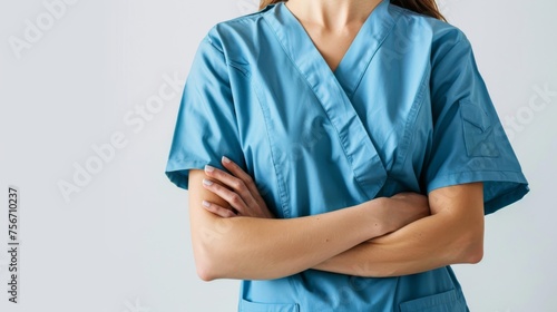 A woman in scrubs stands with crossed arms, exuding confidence and authority
