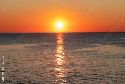 Watching dramatic sunset at coastal village Funtana  Istria  Croatia  EU. Calm sea surface reflects vibrant colors of sky. Vacation at Adriatic Mediterranean Sea. Romantic specular reflection. Sparkle