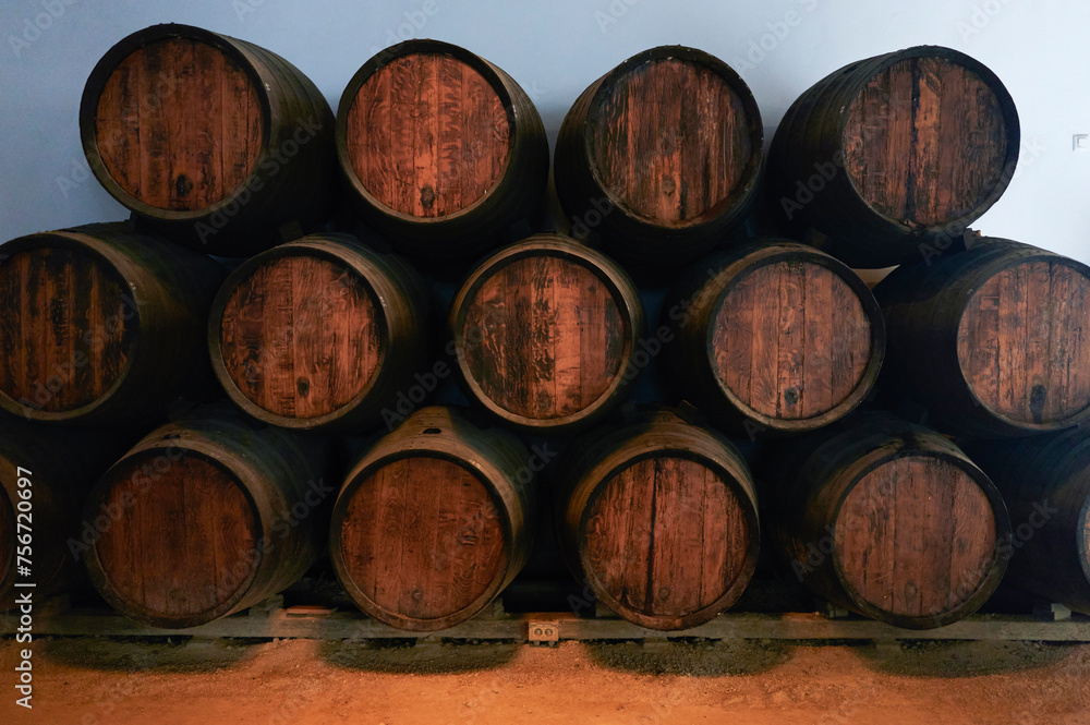 Barrels for whiskey or wine stacked in the cellar