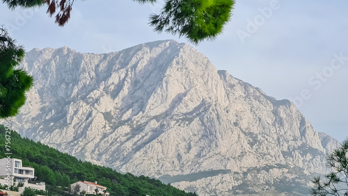 Aleppo pine forest with scenic view of majestic mountain range of Biokovo nature park seen from coastal town Brela, pearl of Makarska Riviera in Dalmatia, Croatia. Wanderlust in remote Dinaric Alps photo