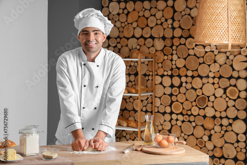 Young chef kneading dough o...