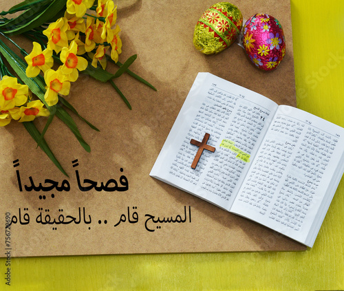 The Arabic text of the Bible Gospel of Luke 24: 5 about Resurrection of Jesus . With a cross, yellow flowers and Easter eggs photo