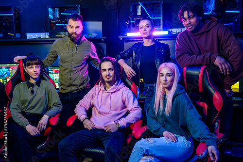 Diverse team of gamers posing while looking at the camera in gameroom