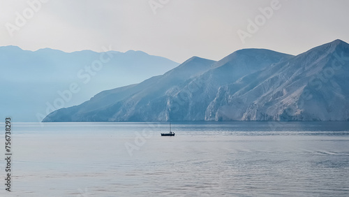 Small sailing boat cruising around archipelago near idyllic coastal town Baska, Krk Island, Primorje-Gorski Kotar, Croatia, Europe. Majestic coastline of Mediterranean Adriatic. Tranquil atmosphere