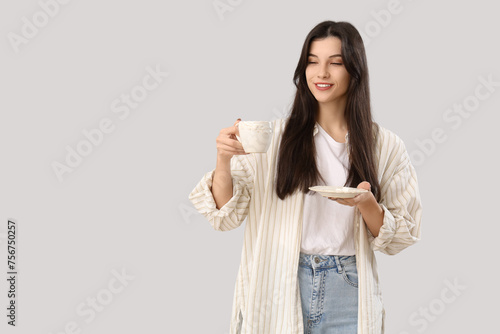 Pretty young woman with cup...